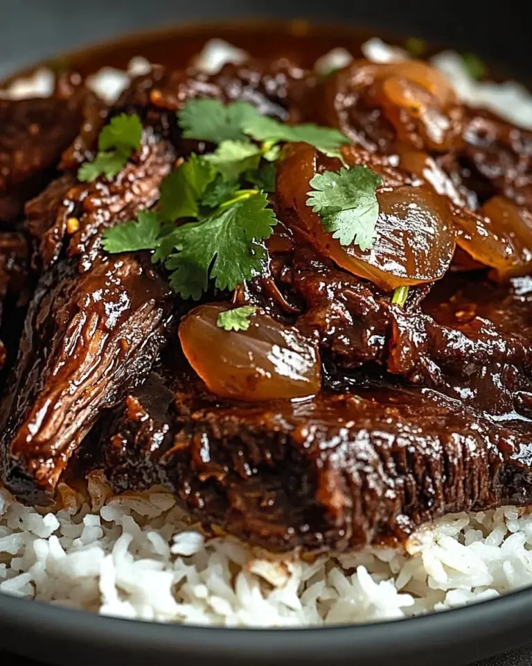 Plate of sweet and savory caramelized pulled beef with herbs and spices